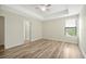 Bright main bedroom featuring a tray ceiling, ceiling fan, wood-look floors, and a large window at 7809 Purple Finch St, Winter Garden, FL 34787