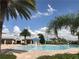 Community splash pad and pool featuring a zero entry, water features, and ample seating with shade and lush landscaping at 7809 Purple Finch St, Winter Garden, FL 34787