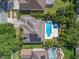 This is an aerial shot of the house with solar panels on the roof and a pool with a jacuzzi in the back yard at 8208 Westminster Abbey Blvd, Orlando, FL 32835
