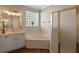 Bright bathroom featuring a soaking tub, a glass block window, and a separate shower stall at 8208 Westminster Abbey Blvd, Orlando, FL 32835