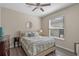 Cozy bedroom with a neutral color scheme, ceiling fan, and window allowing natural light to enter at 8208 Westminster Abbey Blvd, Orlando, FL 32835