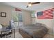 Modern bedroom with a comfortable bed, a large window with blinds, and a dedicated desk space at 8208 Westminster Abbey Blvd, Orlando, FL 32835