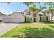 Stately two-story home with a three-car garage, manicured lawn, and mature landscaping with palm trees at 8208 Westminster Abbey Blvd, Orlando, FL 32835