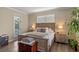 Comfortable bedroom showcasing a wooden bed frame, hardwood floors, and natural light from the window at 8208 Westminster Abbey Blvd, Orlando, FL 32835