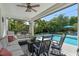 A covered patio features comfortable seating and opens up to a beautiful pool and lush landscaping at 8208 Westminster Abbey Blvd, Orlando, FL 32835