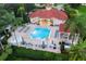 A community pool featuring a pool, hot tub, lounge chairs, and surrounding lush landscape at 8404 Secret Key Cv, Kissimmee, FL 34747