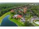 Beautiful aerial view of community featuring a pool, lush landscaping, parking, and red tile roofs at 8404 Secret Key Cv, Kissimmee, FL 34747