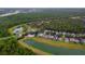 Aerial view showcases community homes with private pools next to a lake at 8404 Secret Key Cv, Kissimmee, FL 34747