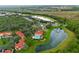 Scenic aerial view showcasing the community, lake, lush landscaping, and nearby natural surroundings at 8404 Secret Key Cv, Kissimmee, FL 34747