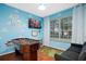 A charming bedroom features light blue cloud painted walls, a foosball table, and a mounted TV at 8404 Secret Key Cv, Kissimmee, FL 34747