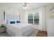 Well-lit bedroom featuring a queen-sized bed with a blue and white headboard and a large window at 8404 Secret Key Cv, Kissimmee, FL 34747