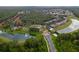 A panoramic aerial view of a vibrant community with mature trees, lakes, and inviting entrance at 8404 Secret Key Cv, Kissimmee, FL 34747