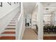 Hallway with wood and white staircase leading to the second floor, adjoining the kitchen and living area at 8404 Secret Key Cv, Kissimmee, FL 34747