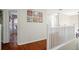 Bright hallway with hardwood floors, white railings, and themed decorations on the wall at 8404 Secret Key Cv, Kissimmee, FL 34747