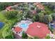 Aerial view of a community pool with a hot tub, lounge chairs, and lush tropical landscaping at 8404 Secret Key Cv, Kissimmee, FL 34747