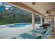 Relaxing pool area features covered patio with ceiling fans, lounge chairs and a dining area at 8404 Secret Key Cv, Kissimmee, FL 34747