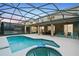 Inviting screened-in pool area with a spa, lounge chairs, and covered patio at 8404 Secret Key Cv, Kissimmee, FL 34747