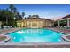 Outdoor pool with lounge chairs, umbrella tables and a covered clubhouse creating a relaxing community space at 8404 Secret Key Cv, Kissimmee, FL 34747