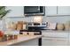 Close up of a kitchen with stainless steel appliances, cutting boards, and a stylish vent hood at 972 Fawn Grace Rd, Umatilla, FL 32784