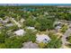 Aerial view of a neighborhood with lush trees, a glimpse of a lake, and a home with a blue driveway at 1228 Vantage Dr, Orlando, FL 32806
