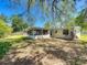 Backyard view showcasing a screened-in porch, a spacious lawn, and mature trees that provide ample shade at 1228 Vantage Dr, Orlando, FL 32806