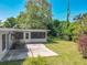 Backyard with a patio, screened-in porch, and lush lawn surrounded by mature trees at 1228 Vantage Dr, Orlando, FL 32806