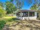 Backyard featuring a screened-in porch, well-maintained lawn, and mature trees offering shade at 1228 Vantage Dr, Orlando, FL 32806