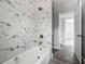 Bathroom featuring white marbled tile, updated fixtures, and tile tub at 1228 Vantage Dr, Orlando, FL 32806
