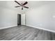 Spacious bedroom with gray wood-look floors, ceiling fan, and neutral walls at 1228 Vantage Dr, Orlando, FL 32806
