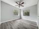 Bedroom with modern ceiling fan, two windows offering natural light, and sleek laminate floors at 1228 Vantage Dr, Orlando, FL 32806