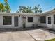 Home exterior showcasing a screened-in porch, a concrete patio, and lush landscaping at 1228 Vantage Dr, Orlando, FL 32806