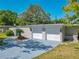 Well-maintained home with a spacious driveway, two-car garage, and lush greenery at 1228 Vantage Dr, Orlando, FL 32806