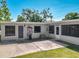 Exterior shot highlighting the screened-in porch, concrete patio, and landscaping of the residence at 1228 Vantage Dr, Orlando, FL 32806