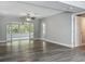Bright living area featuring new flooring, gray walls, and an exit to a screened-in patio at 1228 Vantage Dr, Orlando, FL 32806