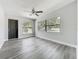 Bright living room with gray walls, wood floors, a ceiling fan, and two large windows at 1228 Vantage Dr, Orlando, FL 32806