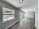 Spacious living room featuring modern gray walls, sleek laminate floors, and a large window at 1228 Vantage Dr, Orlando, FL 32806