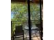 Cozy balcony with a round table, chairs, and a view of lush greenery at 12527 Floridays Resort Dr # 311E, Orlando, FL 32821