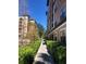 A walkway lined with landscaping between two well-maintained buildings in a resort community at 12527 Floridays Resort Dr # 311E, Orlando, FL 32821