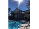 A luxurious swimming pool area with palm trees at a beautiful resort property on a clear day at 12527 Floridays Resort Dr # 311E, Orlando, FL 32821