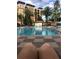 A refreshing swimming pool surrounded by palm trees and resort buildings, offering a tranquil escape at 12527 Floridays Resort Dr # 311E, Orlando, FL 32821