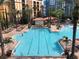 Large swimming pool surrounded by lounge chairs and palm trees, perfect for relaxation at 12527 Floridays Resort Dr # 603E, Orlando, FL 32821