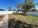 Spacious backyard featuring a white fence, large trees, and stone walkway at 1819 E Chapel Dr, Deltona, FL 32738