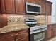 Close up of kitchen with stainless steel appliances, granite counter tops, and wood cabinets at 1819 E Chapel Dr, Deltona, FL 32738