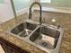Stainless steel double bowl sink with faucet set in granite countertop at 1819 E Chapel Dr, Deltona, FL 32738