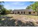 Expansive backyard featuring a patio for grilling and lounge furniture, surrounded by a lush, green landscape at 132 Alachua Dr, Winter Haven, FL 33884