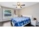 Cozy bedroom featuring a comfortable bed with blue patterned bedding, dark wood floors, and natural light at 132 Alachua Dr, Winter Haven, FL 33884
