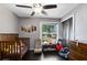 Comfortable bedroom featuring wood floors, a ceiling fan, and a large window that provides natural light at 132 Alachua Dr, Winter Haven, FL 33884