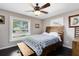 Comfortable bedroom featuring a wooden bed frame, dark wood floors, and natural light from two windows at 132 Alachua Dr, Winter Haven, FL 33884