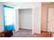 A bedroom with neutral carpet featuring a closet, window, and bright blue curtains at 184 Lake Smart Cir, Winter Haven, FL 33881