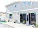 Back exterior of home featuring glass sliding doors leading to the backyard, a grassy area, and a simple patio at 184 Lake Smart Cir, Winter Haven, FL 33881